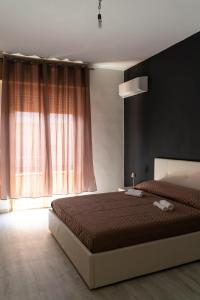 a bedroom with a bed and a large window at Monfalcone City Room Rental Apartment in Cagliari