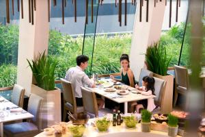 een gezin aan een tafel in een restaurant bij The Westin Grande Sukhumvit, Bangkok in Bangkok