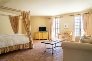 a bedroom with a bed and a couch and a table at Château les Crostes in Lorgues