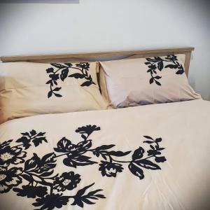 Cama con sábanas y almohadas blancas y negras en Centrally Apartment - Xanthi, en Xanthi