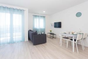 a white living room with a table and a couch at Delminium in Kaštela