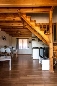 a large living room with wooden floors and wooden stairs at Bajkowe domki in Sarbinowo