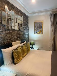 a bedroom with a large bed with gold pillows at MAKATI Isabela Luxury in Manila