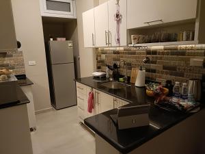 a kitchen with a black counter top and a refrigerator at WestLuxApartment in Al Karnak