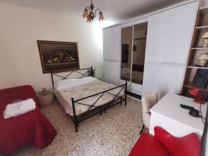 a bedroom with a bed and a chair and a mirror at Home Egitto 53 in Modica