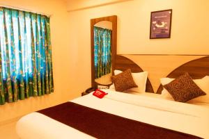 a hotel room with a bed and two windows at OYO Hotel Royal Grand Near Chhatrapati Shivaji International Airport in Mumbai