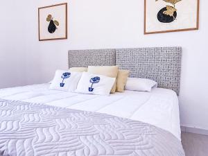 1 dormitorio con 1 cama blanca y 2 almohadas en Liguria Terrace, en Olbia