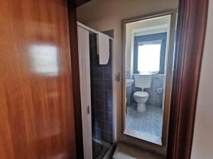 een badkamer met een toilet en een raam en een deur bij Home Egitto 53 in Modica