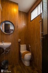 a bathroom with a toilet and a sink and a mirror at Blue Lagoon Hotel in Chiang Rai