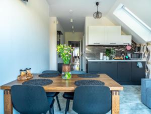 une cuisine avec une table en bois et des chaises bleues dans l'établissement Latarnik - luksusowe apartamenty w Stilo, à Osetnik