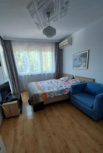 a bedroom with a bed and a blue couch at Villa Detelina Balchik in Balchik