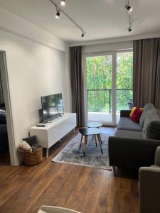 un soggiorno con un divano e una TV di Sosnowe Apartamenty - Marina 3 a Augustów