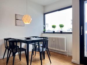a dining room with a black table and chairs at Two Bedroom Apartment In Glostrup, Hovedvejen 182, in Glostrup
