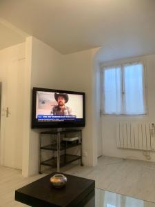 a flat screen tv in a living room with a window at Chambre privée avec partage des espaces communs in Créteil