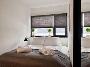 a bedroom with a large bed with two windows at Two Bedroom Apartment In Glostrup, Hovedvejen 182, in Glostrup