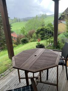 ヒンターツァルテンにあるFerienhaus Rotzingerの野原の景色を望むデッキの木製テーブル