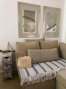 a couch sitting in a room with two pictures on the wall at Luxury sea-apartment in Skala Fourkas in Skála Foúrkas
