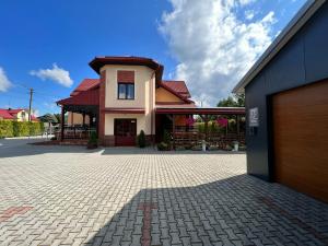 uma casa com uma entrada de tijolos em frente a uma garagem em Hotel Ostoja em Bobowa