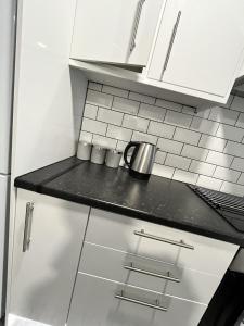 a kitchen with white cabinets and a counter top at Cozzzy Seaside Retreat in Mablethorpe