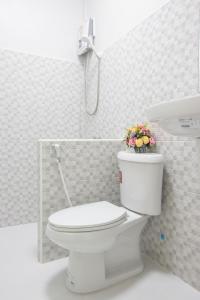 ein weißes Bad mit einem WC und einem Blumentopf darauf in der Unterkunft Tonsoi Hathairat in Ban Tao Pun