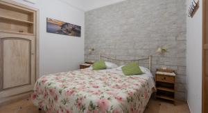 a bedroom with a bed and a brick wall at Maristella in Positano