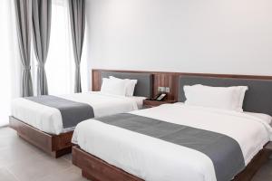 two beds sitting next to each other in a bedroom at Emerald Residence Kampot in Kampot +59 photos