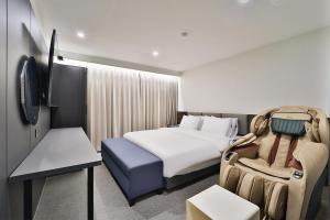 a hotel room with a large bed and a chair at DOAN STAY HOTEL in Ulsan