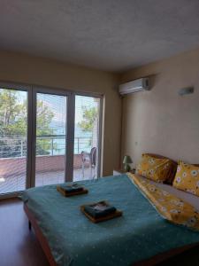 1 dormitorio con 1 cama grande y balcón en PS Apartments - Peshtani en Peštani
