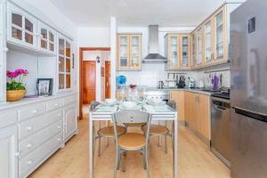 a white kitchen with a table and chairs in it at Summer Dreams Beach House in Playa Honda