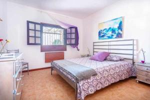 a bedroom with a bed and a dresser and a window at Summer Dreams Beach House in Playa Honda