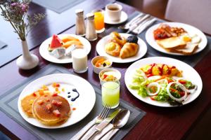 a wooden table with plates of food on it at Best Western Plus Wanda Grand Hotel in Nonthaburi