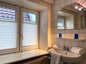 baño con lavabo y ventana en Nordwind, Hafenstraße, en Wyk auf Föhr