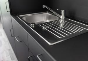 a stainless steel kitchen sink in a black counter top at Simotel in Aussersiggam