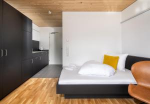1 dormitorio pequeño con 1 cama y 1 silla en Simotel, en Aussersiggam
