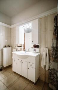 een badkamer met een witte wastafel en een spiegel bij Rahes Villa with Private Pool in Zakynthos