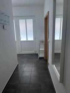 a hallway with two windows and a tiled floor at EICstay - Ferienhaus für Monteure und Familie in Worbis