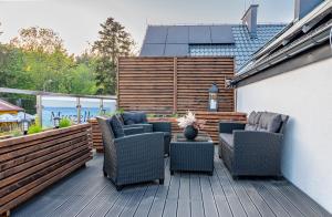 eine Terrasse mit 4 Stühlen und einem Tisch auf einer Terrasse in der Unterkunft Latarnik - luksusowe apartamenty w Stilo in Osetnik