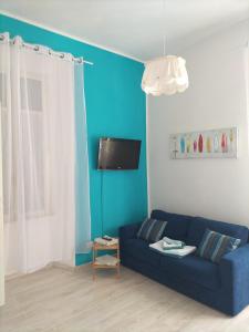 sala de estar con sofá azul y TV en Maison De Revel, en Civitavecchia