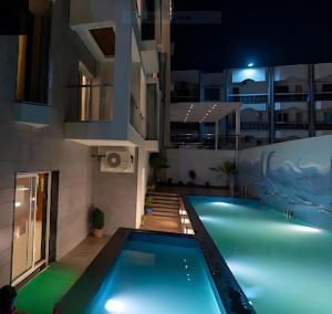 a swimming pool in the middle of a building at night at New Gitanjali Hotel, New Digha in Digha