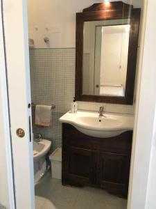 La salle de bains est pourvue d'un lavabo, de toilettes et d'un miroir. dans l'établissement Monolocale a due passi dal centro il glicine, à Urbino