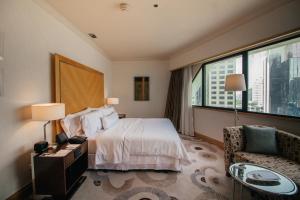 a hotel room with a bed and a chair and a window at The Westin Grande Sukhumvit, Bangkok in Bangkok