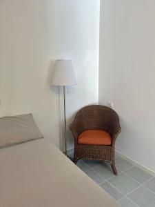 - une chambre avec un lit, une chaise et une lampe dans l'établissement Monolocale a due passi dal centro il glicine, à Urbino