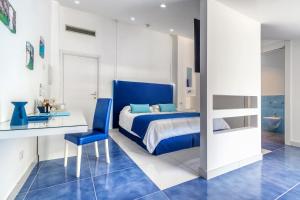 una camera da letto blu e bianca con letto e scrivania di Hotel Metropole a Sorrento