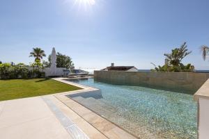 a swimming pool in a villa with the ocean in the background at Villa Endless Summer in Estepona