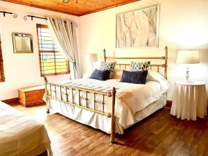 a bedroom with a large bed and a window at Eikelaan Farm Cottages in Tulbagh