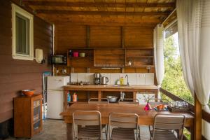 a kitchen with a table and chairs in a room at Hakuna Matata Holidays wooden lodge with airco & pool in Greek Olive Grove in Methoni