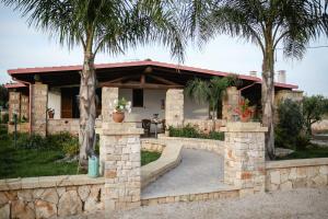 a house with palm trees in front of it at Ugento Country Cottage - Villa con Piscina in Ugento