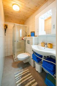 a bathroom with a toilet and a sink and a shower at Hakuna Matata Holidays wooden lodge with airco & pool in Greek Olive Grove in Methoni
