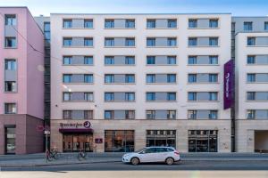 ein weißes Auto, das vor einem Gebäude parkt in der Unterkunft Premier Inn Nürnberg City Centre in Nürnberg