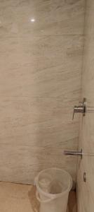 a toilet in a bathroom with a bucket at Hotel Krishna in Katra